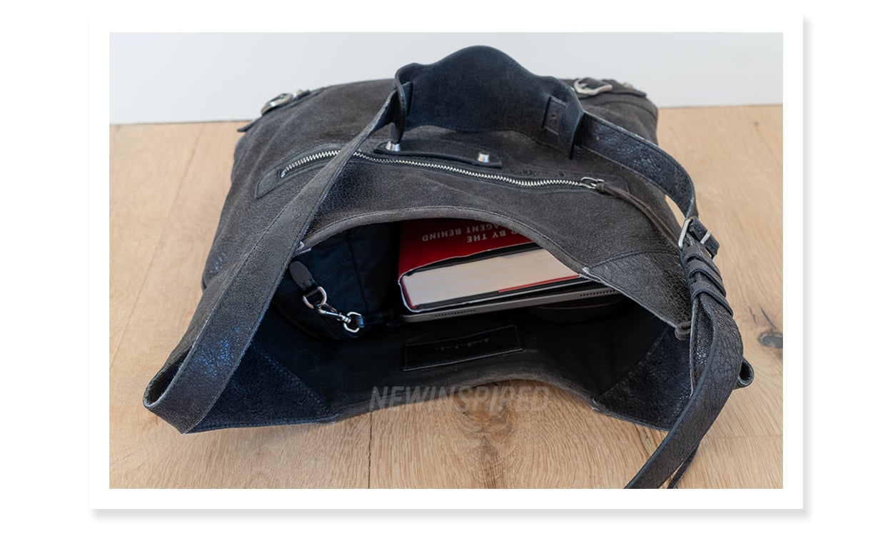 A hardcover book, iPad, Laptop, and essentials pouch fit in a Balenciaga Besace bag